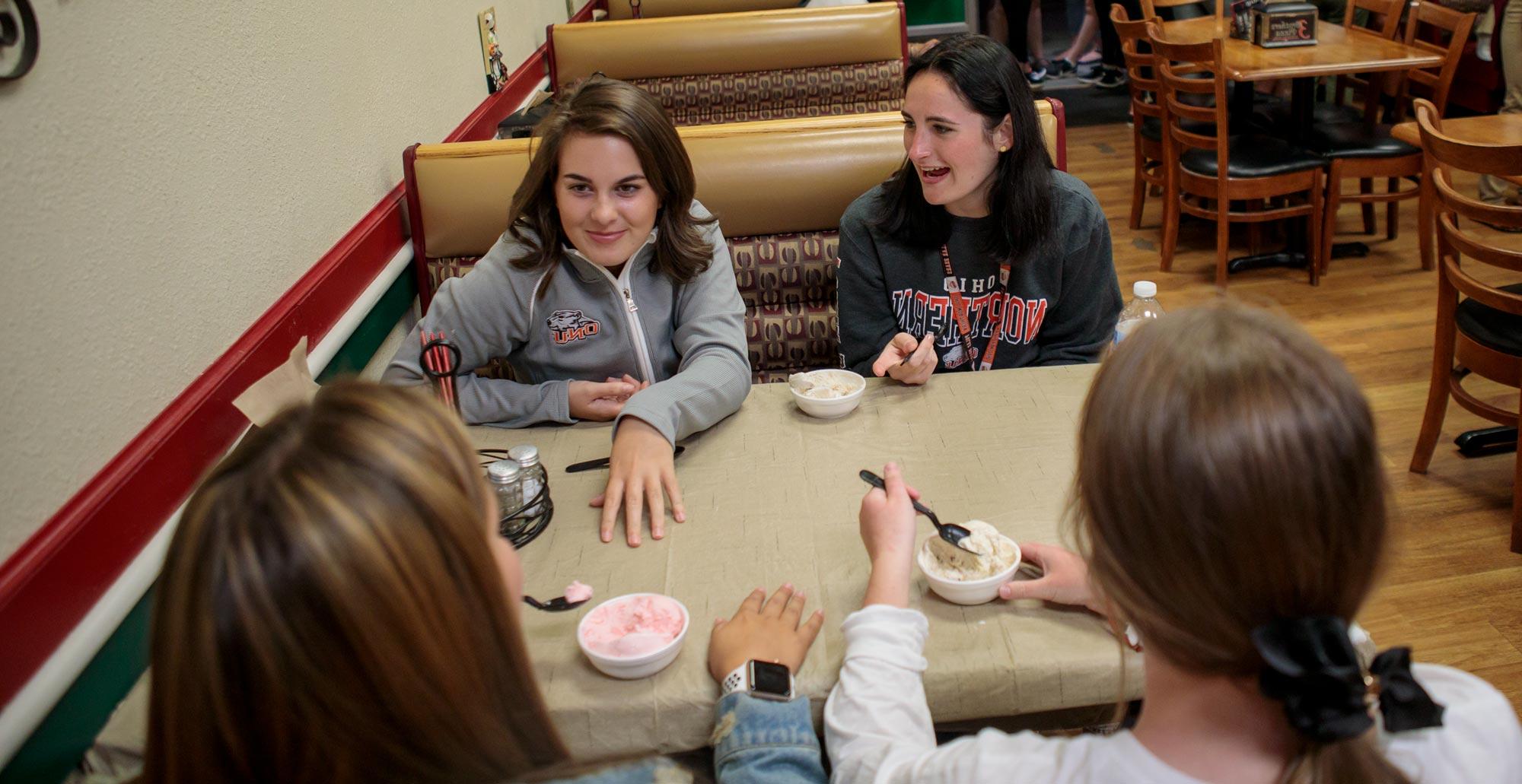从左, 药学一年级学生丹尼斯·威廉姆斯和一年级学生伊莎贝拉·奥罗菲诺在三兄弟披萨店边聊天边吃冰淇淋. 